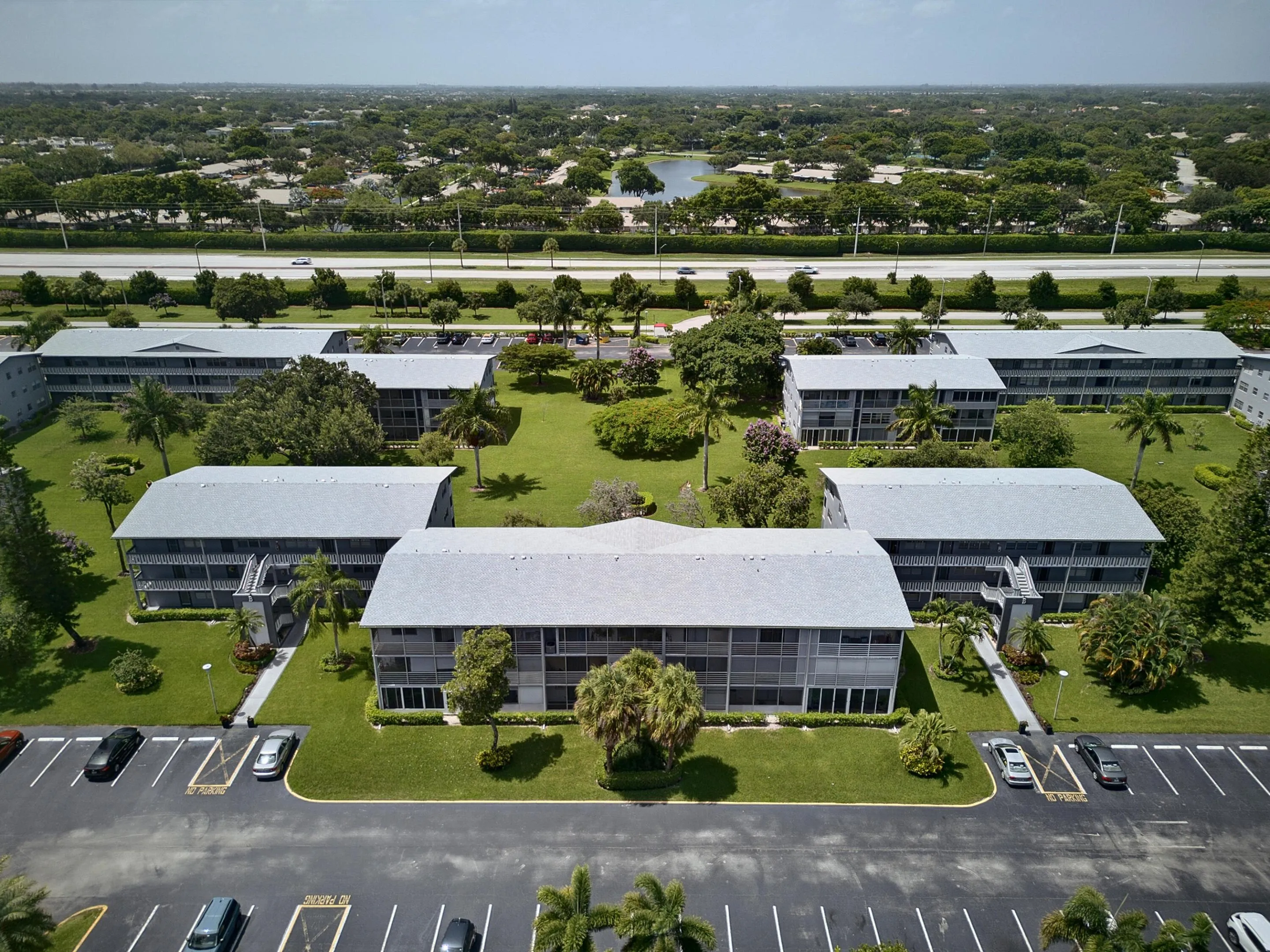 Multi-building complex featuring gray roofs and screened balconies