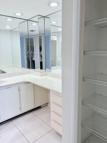 Vanity area with a linen closet.