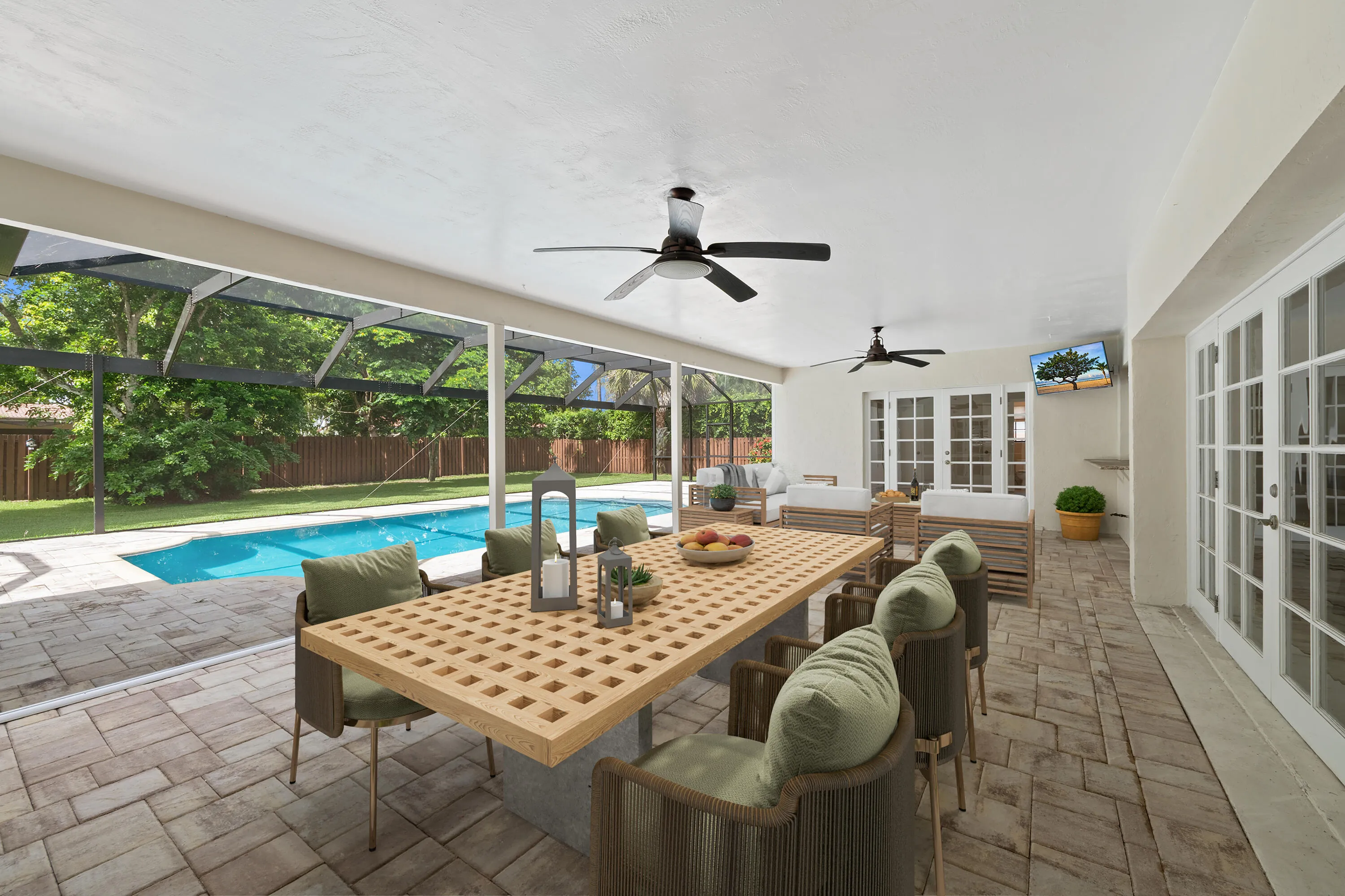 Spacious screened patio featuring a swimming pool, paver flooring, multiple ceiling fans, and French doors