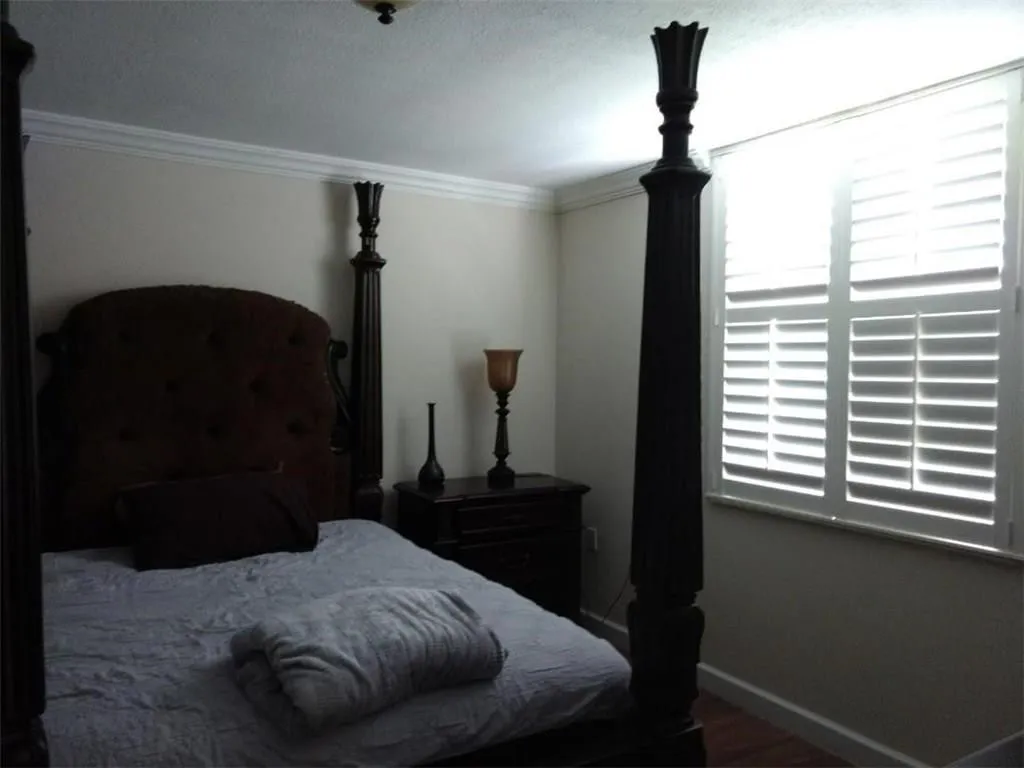 White plantation shutters complement the interior, accompanied by crown molding and baseboards