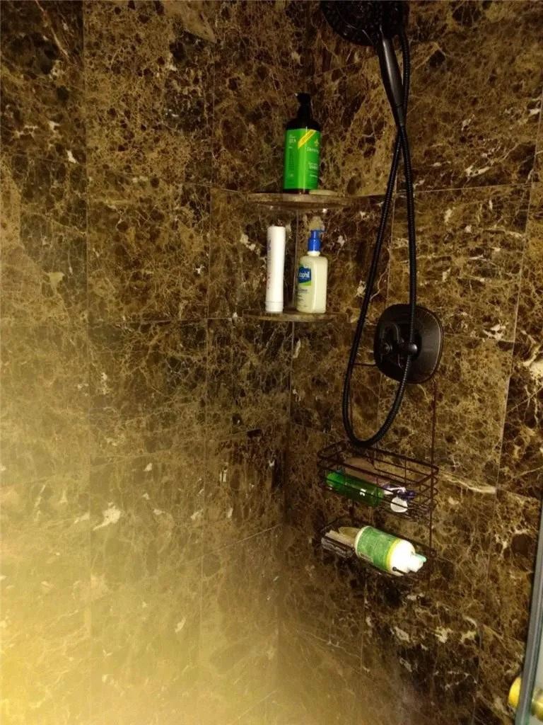 Shower enclosure featuring stone-look wall and floor tile
