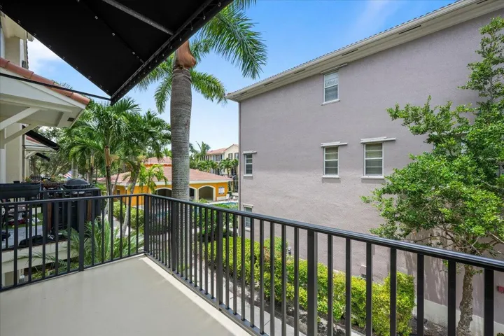 Balcony featuring black metal railings and a black retractable awning