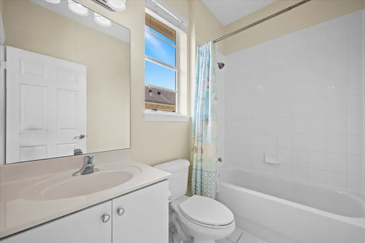 Bathroom featuring a white vanity with an integrated sink, polished chrome faucet, and overhead lighting