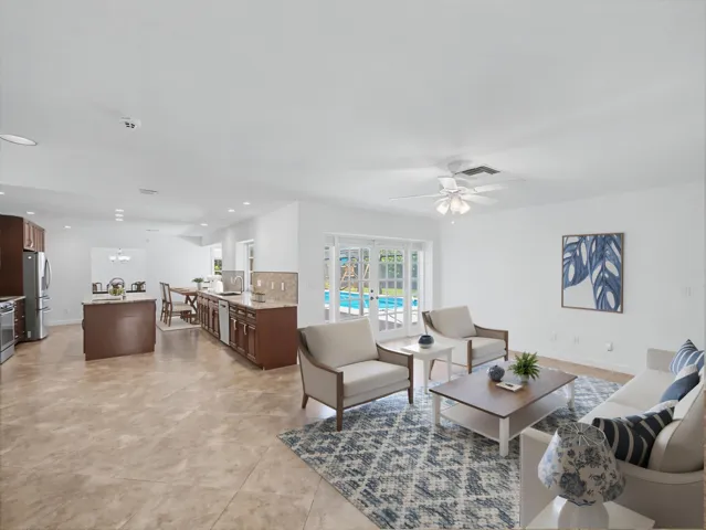 Open-concept interior featuring light-toned tile flooring throughout - Virtually Staged