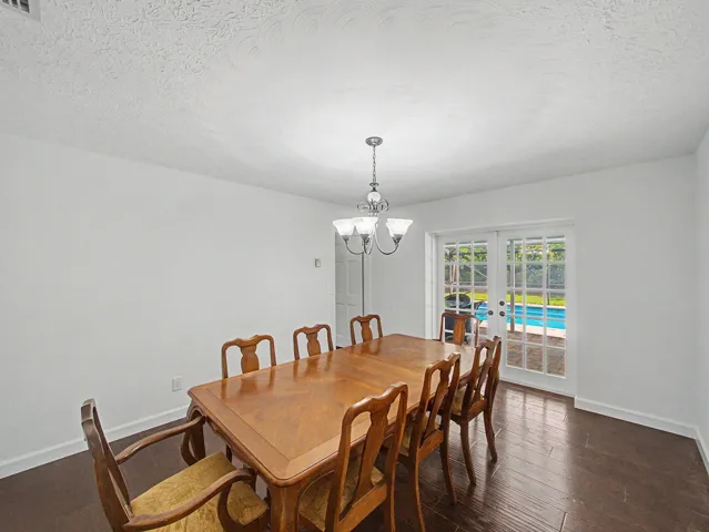 Bright interior space featuring white walls and dark wood-finish flooring