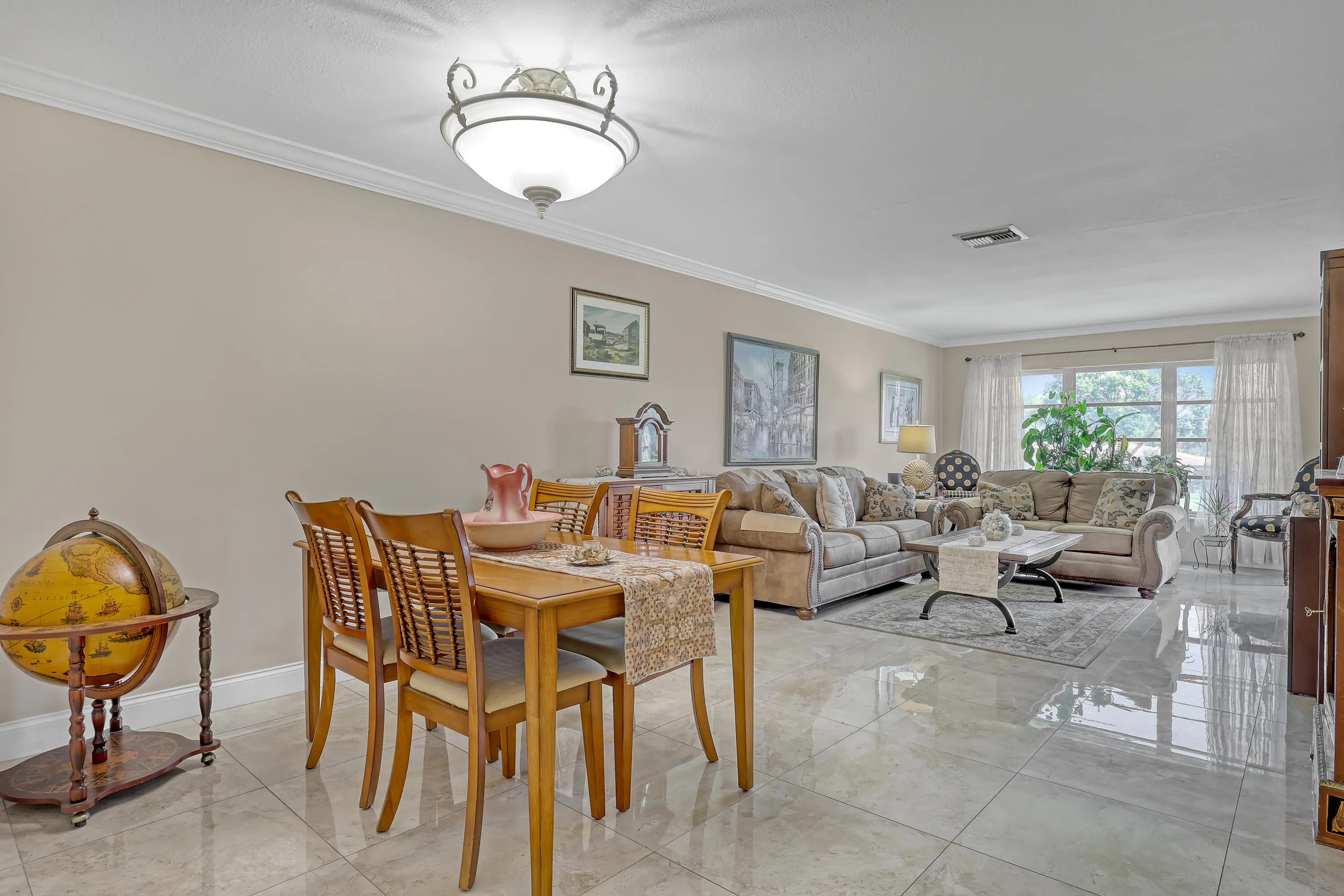 Dining area featuring a wood-finish dining table and chairs, crown molding, and a semi-flush mount light fixture