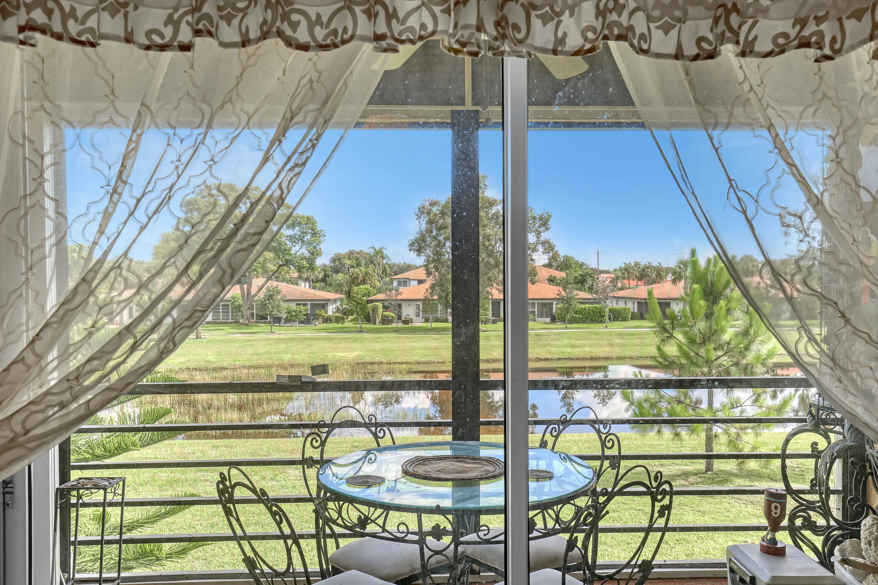 Screened balcony with water feature and distant residential structures