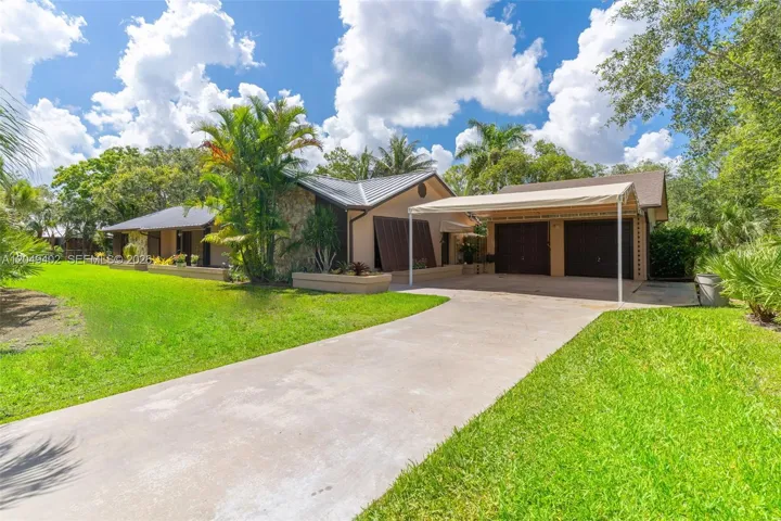 FRONT OF THE HOME WITH PAVED DRIVEWAY LEADING TO DETACHED OVERSIZED 2 CAR GARAGE