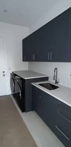 Laundry room with quartz countertops, high end W/D, utility sink and generous folding area.
