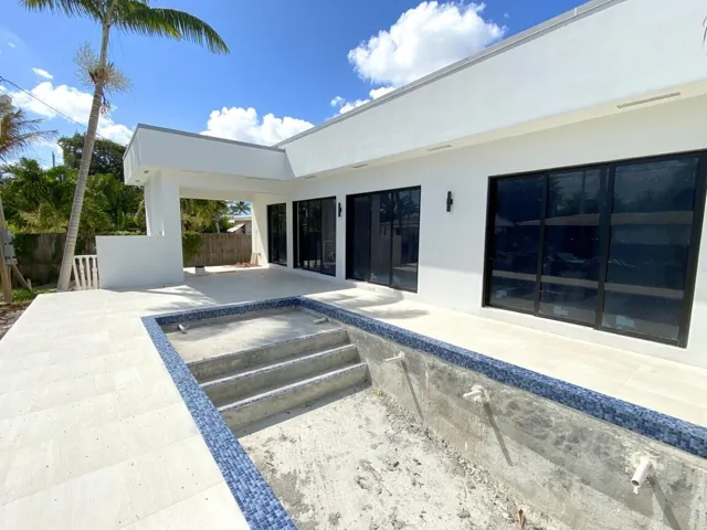 Pool showcasing high end tile border/coping, sun shelf and covered patio area.