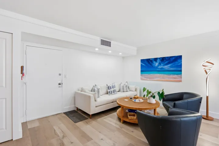 Spacious living area featuring luxury vinyl flooring, recessed lighting, and crown molding