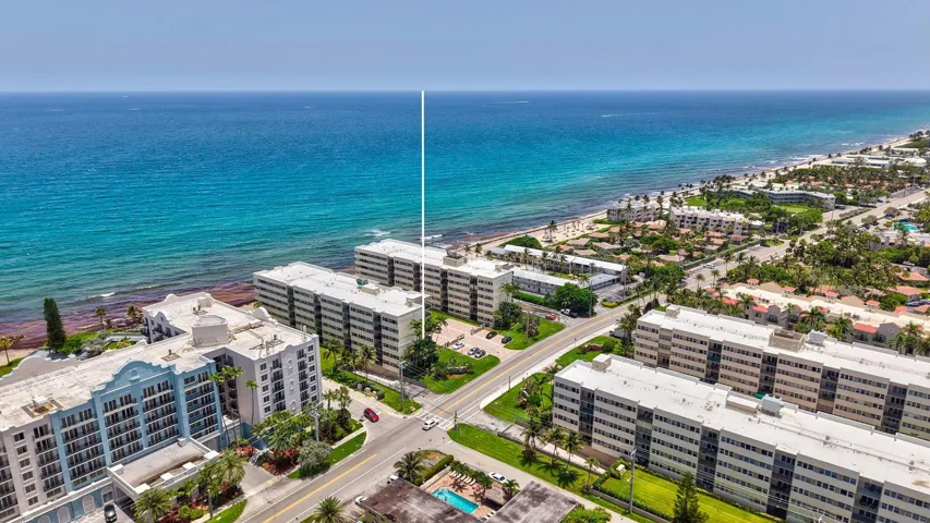 Coastal property featuring direct ocean frontage, a sandy beach, and multiple multi-story buildings