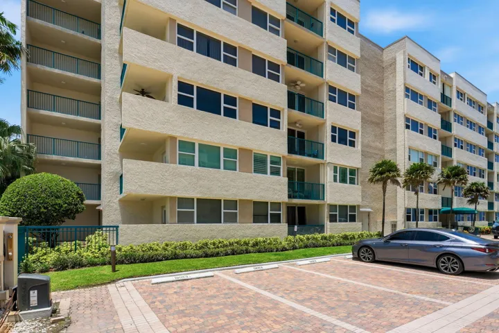 Multi-story residential building with textured exterior finish and multiple private balconies.