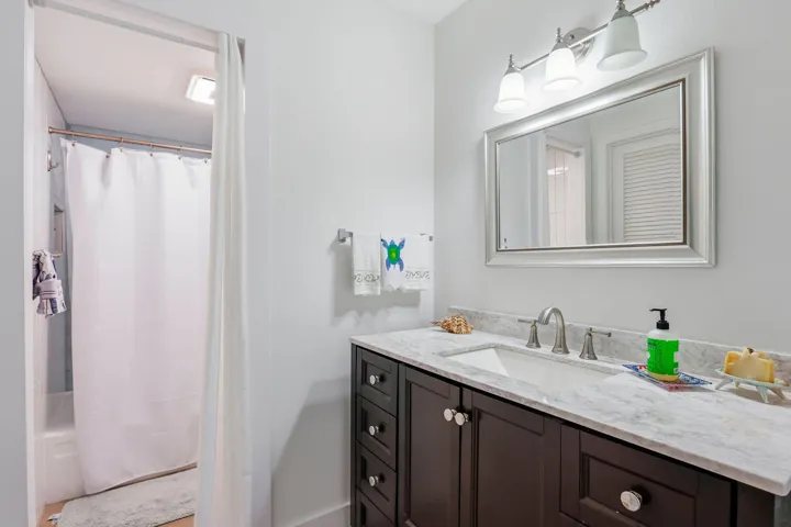 Bathroom vanity featuring a light-toned countertop, an undermount sink, and a brushed nickel faucet
