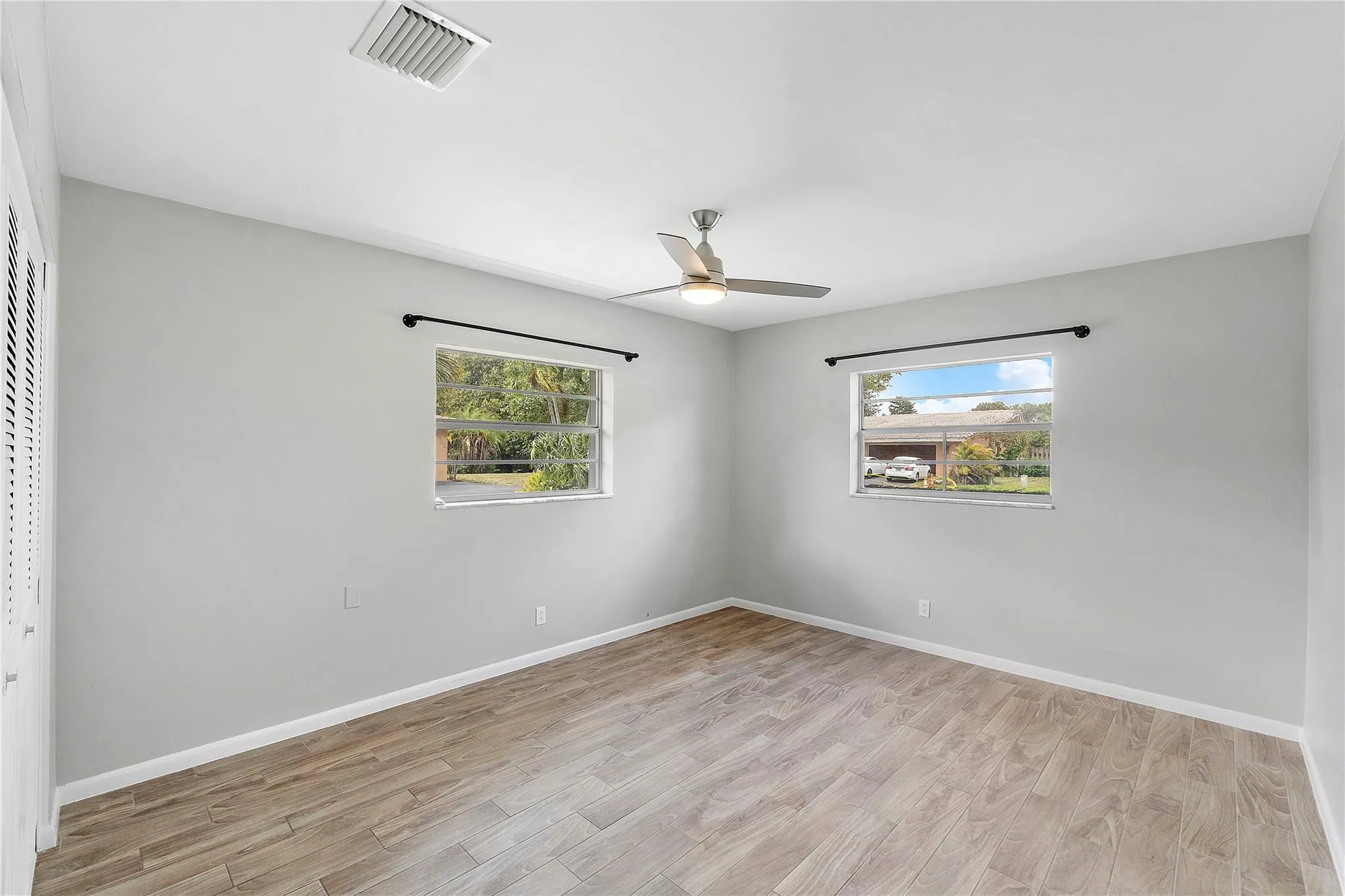 Neutral-toned room featuring wood-finish flooring and light gray walls
