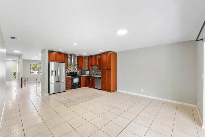 Kitchen featuring wood cabinetry, stainless steel appliances, and a mosaic tile backsplash