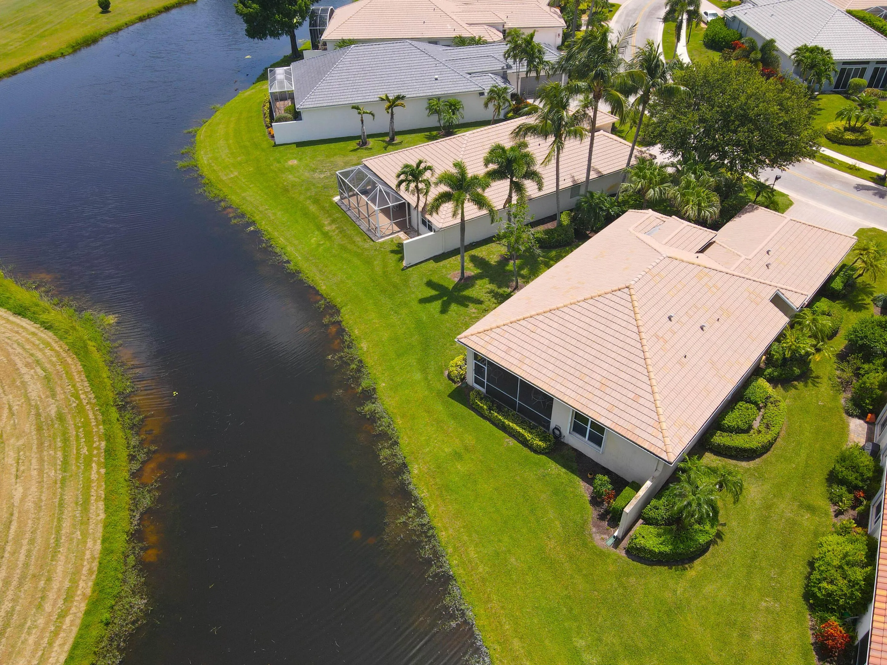 Waterfront property featuring extensive green lawns and mature landscaping