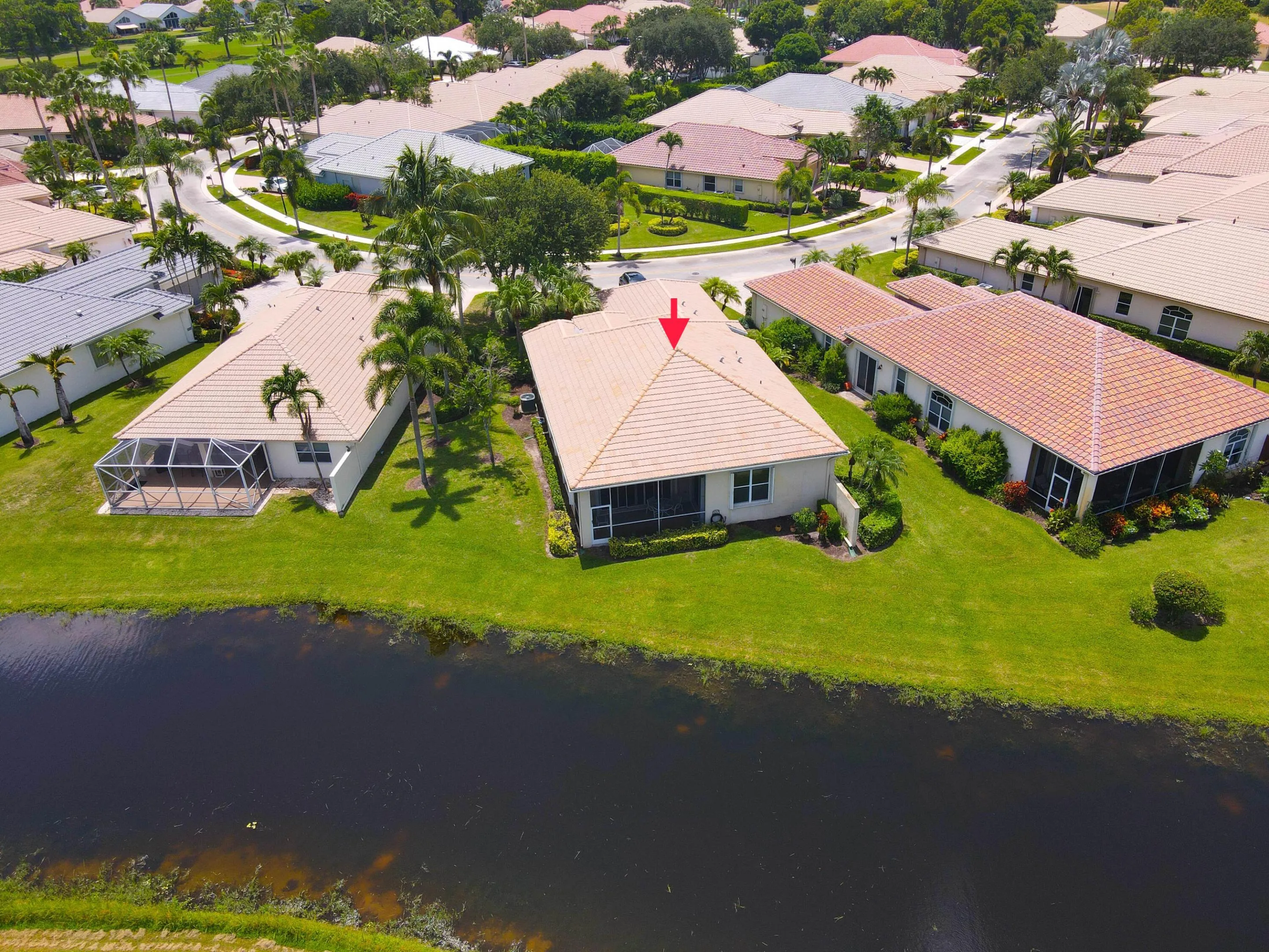 Waterfront property featuring a screened patio and manicured lawn