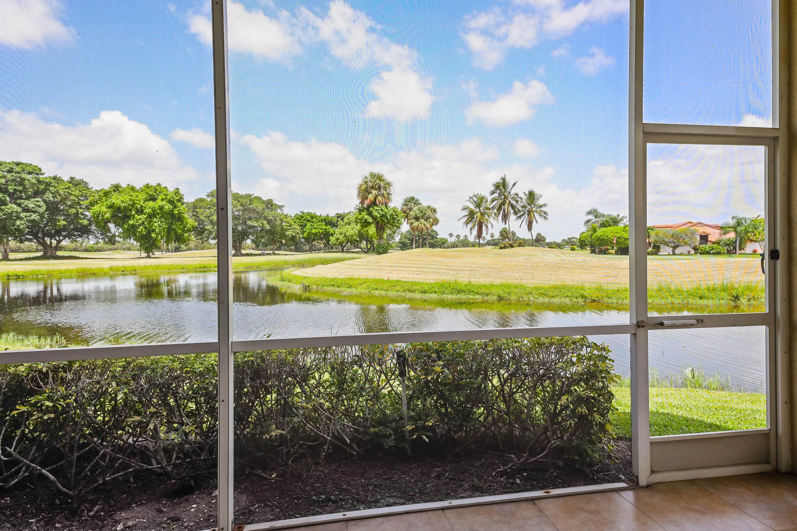 Screened patio offering expansive water frontage with natural landscaping and mature trees