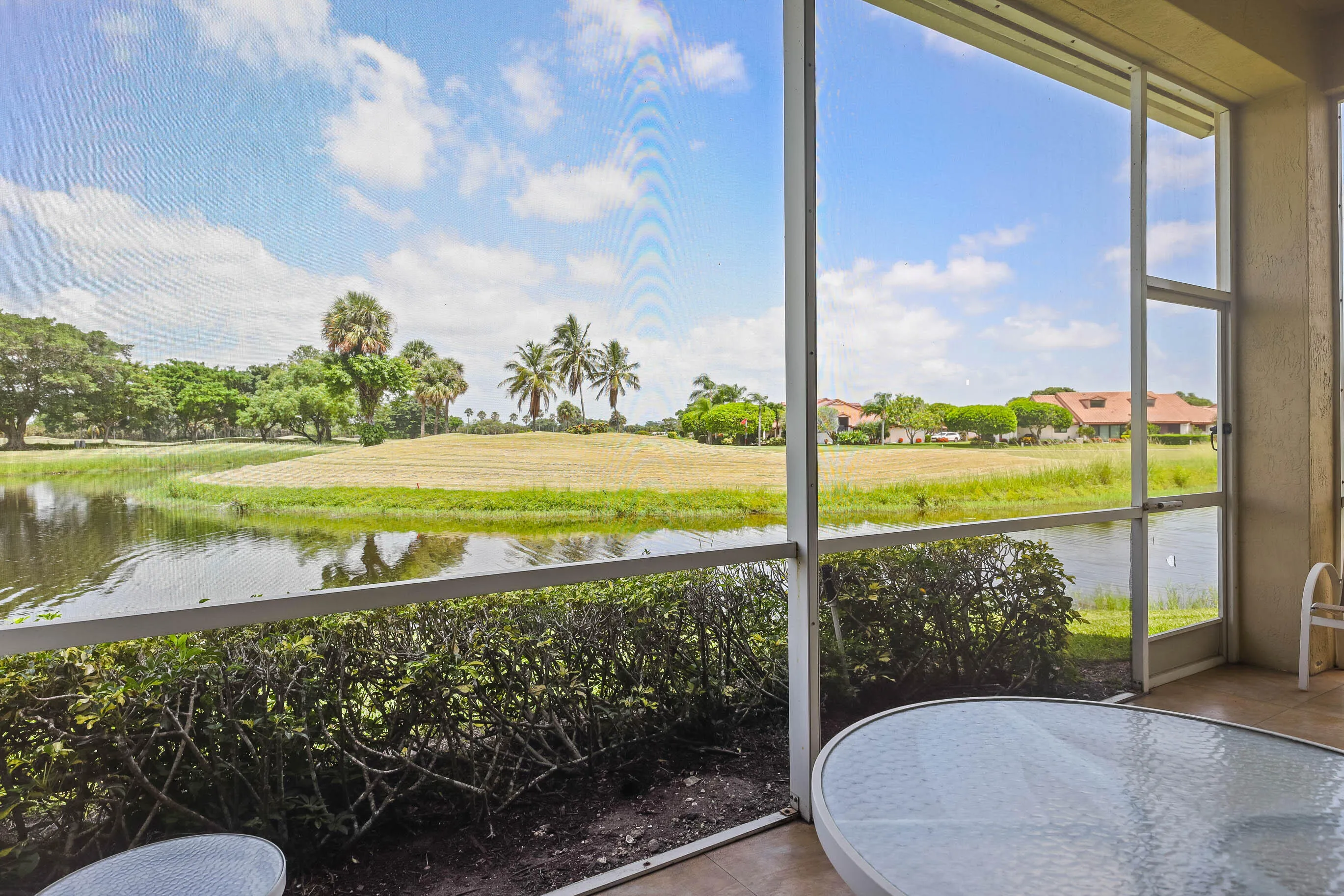 Screened patio overlooking a water feature and expansive green space