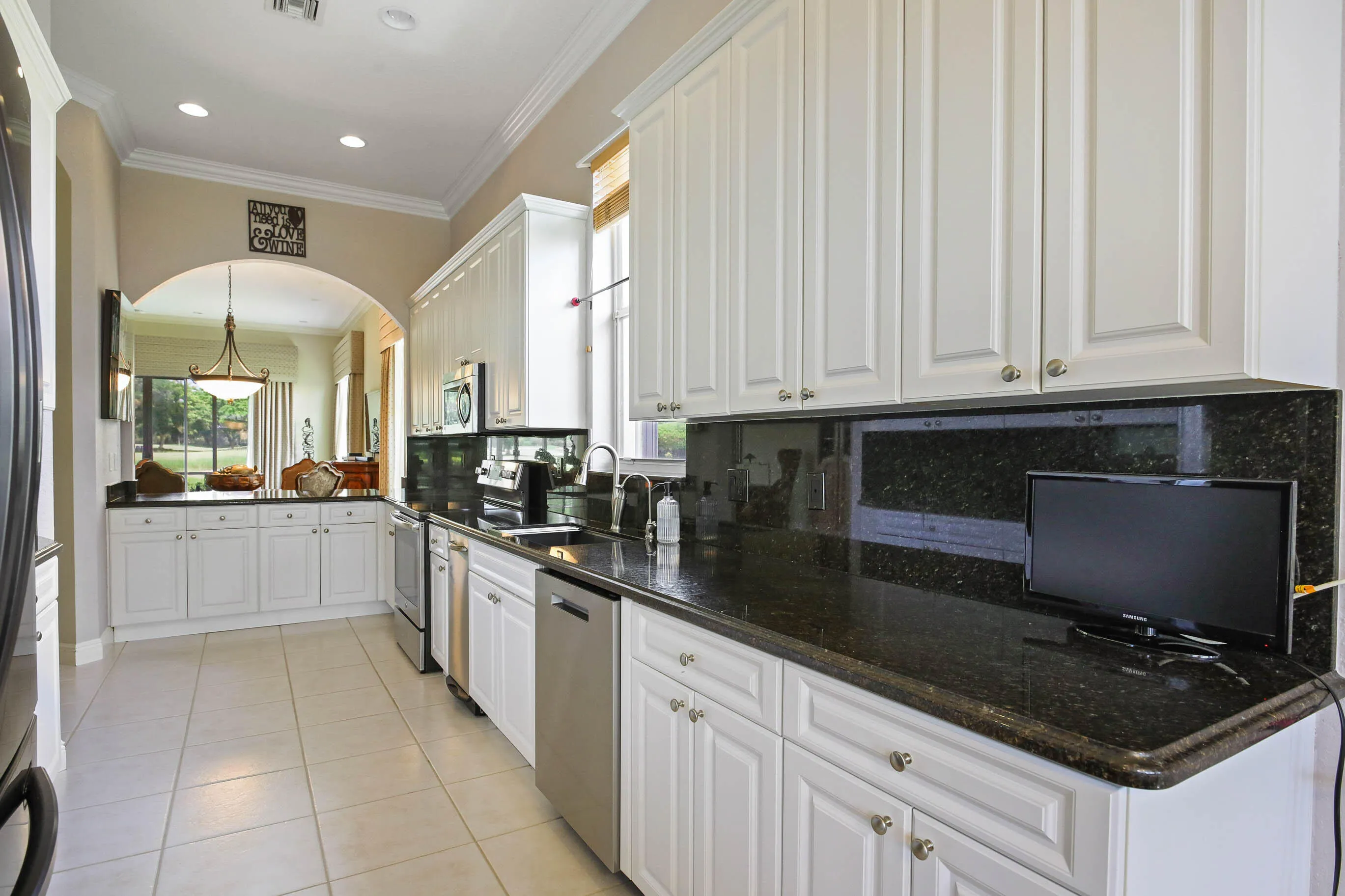 Kitchen featuring white cabinetry, dark stone countertops, and stainless-steel appliances