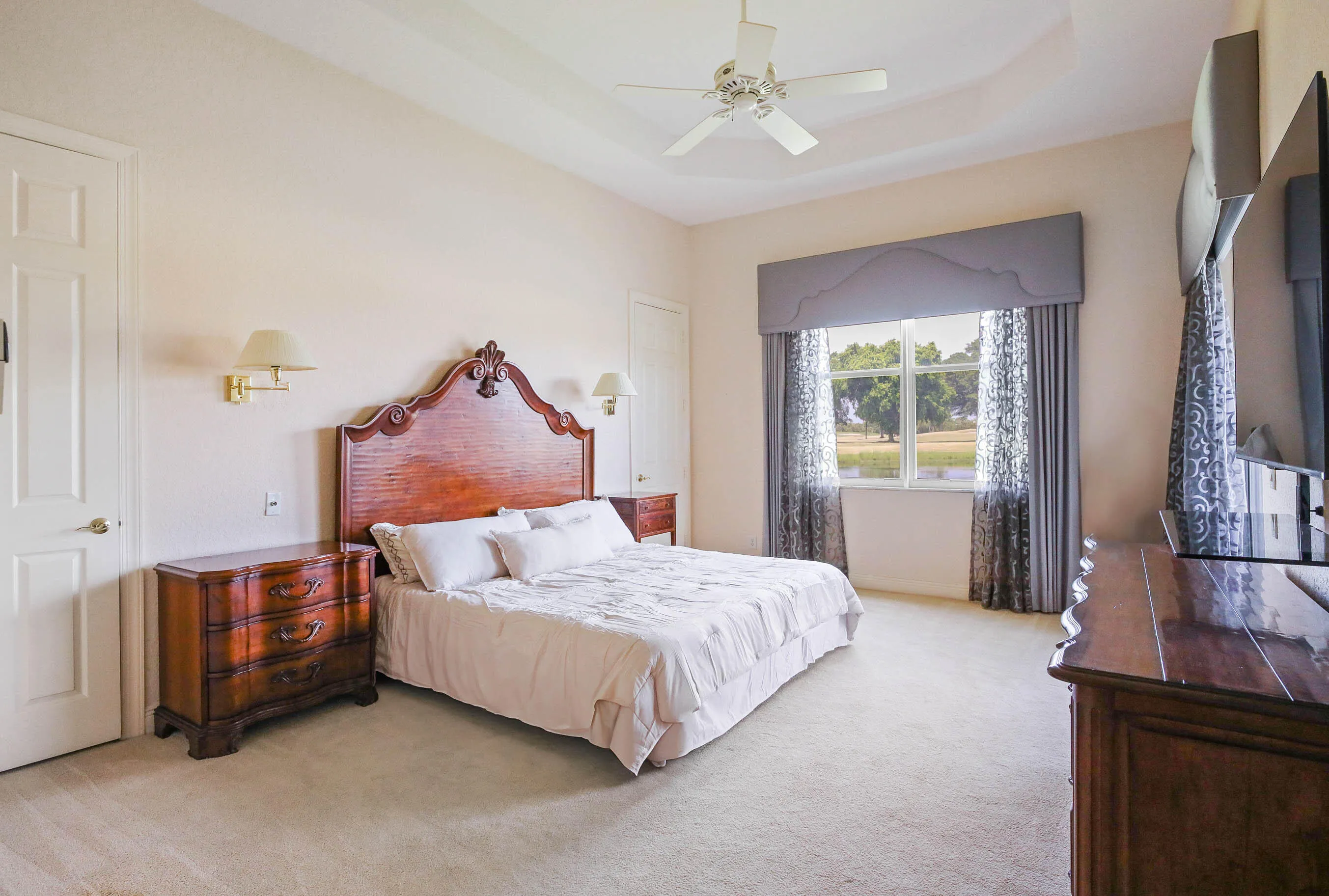 Carpeted bedroom with a tray ceiling