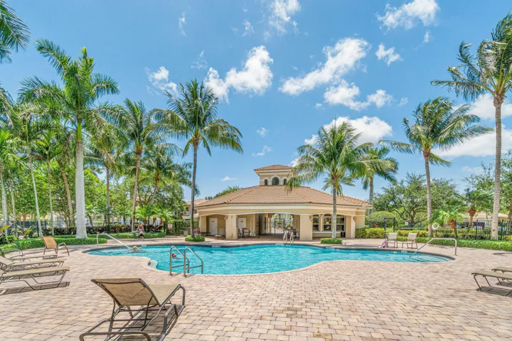 Resort-style pool area featuring a freeform swimming pool, integrated spa, and a surrounding paver deck