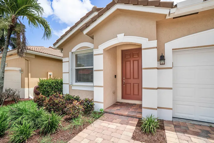 Exterior featuring a tile roof, stucco siding, decorative trim.