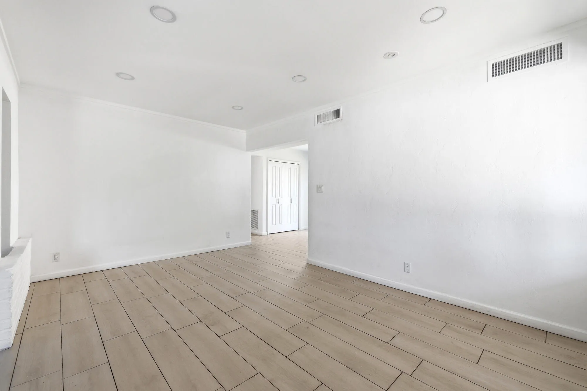 Spacious room with light wood-finish flooring, recessed lighting, and crown molding