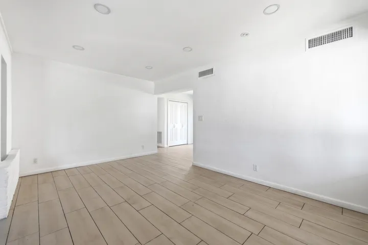 Spacious room with light wood-finish flooring, recessed lighting, and crown molding
