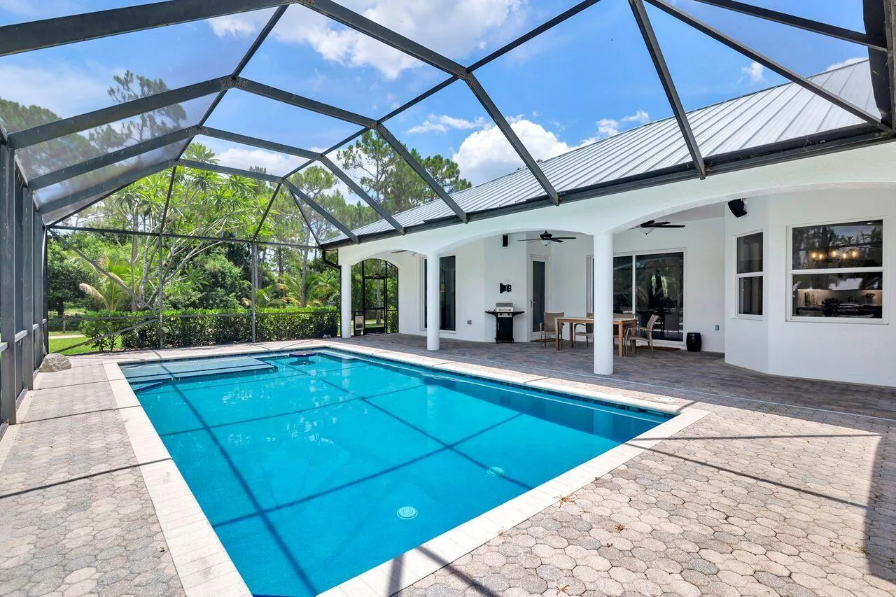 Expansive screened lanai featuring a swimming pool, paver deck, and covered patio