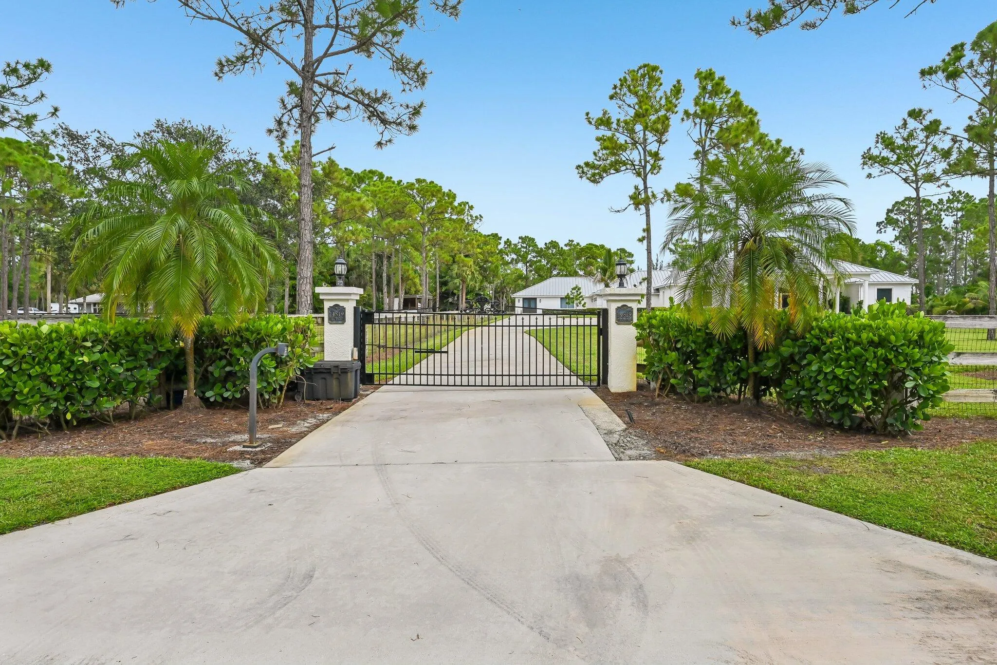 Spacious front lawn with mature trees and a circular driveway