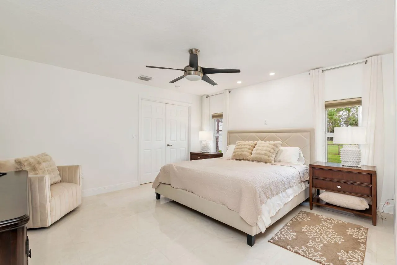 Spacious Primary bedroom featuring, white walls, and a contemporary ceiling fan