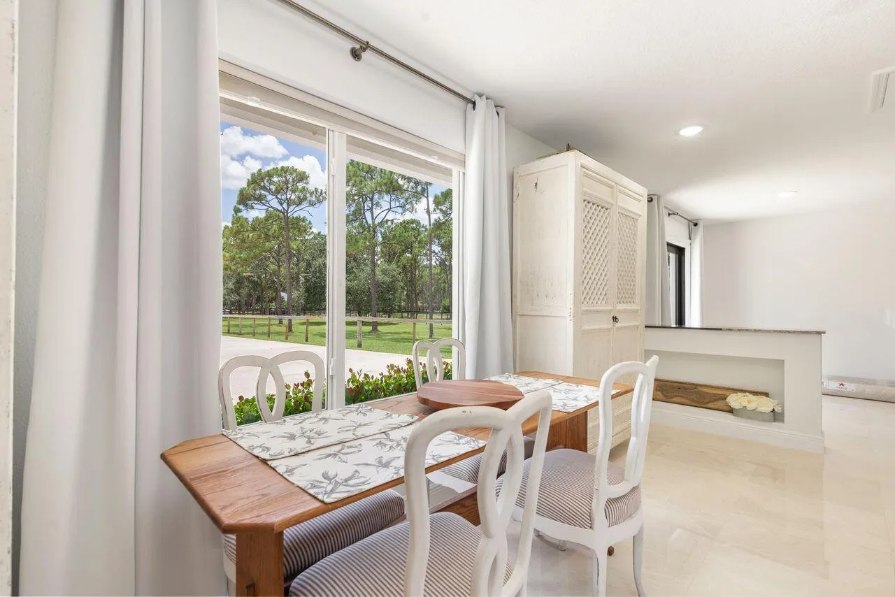 Dining area featuring large sliding glass doors, recessed lighting, and a half-wall partition