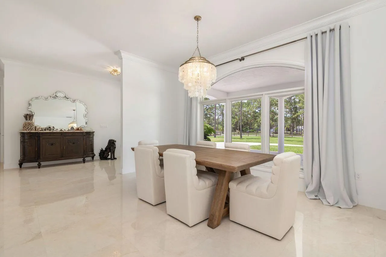 Dining area featuring a large arched window, a decorative chandelier.