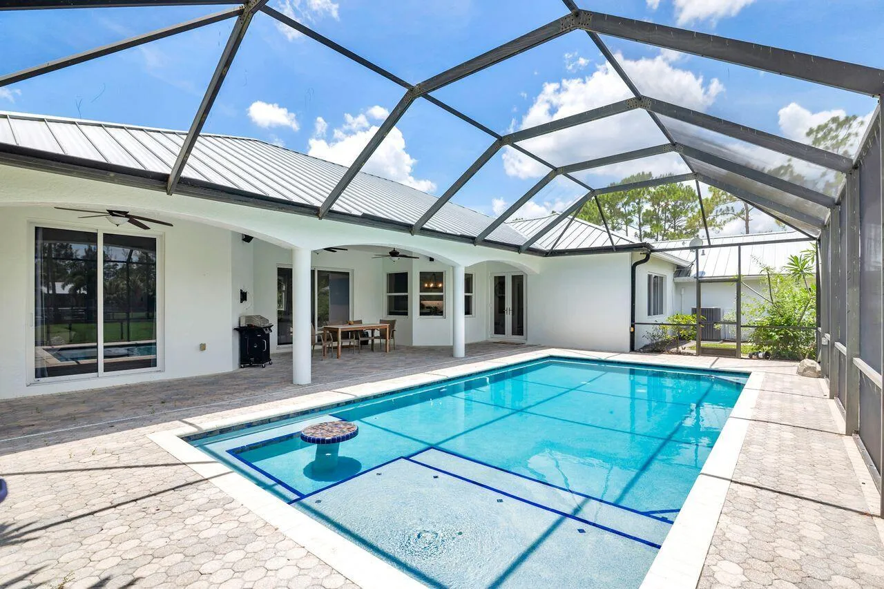 Screened swimming pool enclosure with paver patio