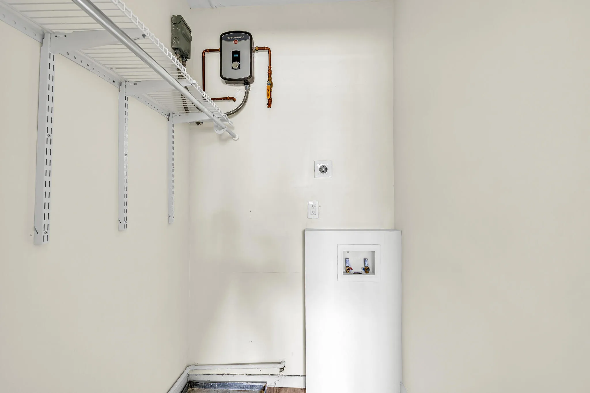 Guest room closet with tankless wtaer heater and washer/dryer hookup