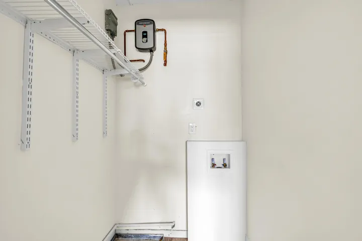 Guest room closet with tankless wtaer heater and washer/dryer hookup