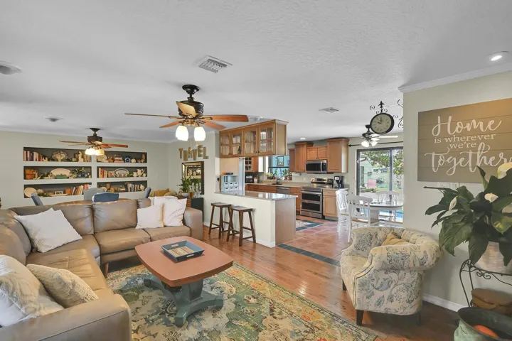 Spacious common area featuring wood-finish flooring, recessed lighting, and ceiling fans