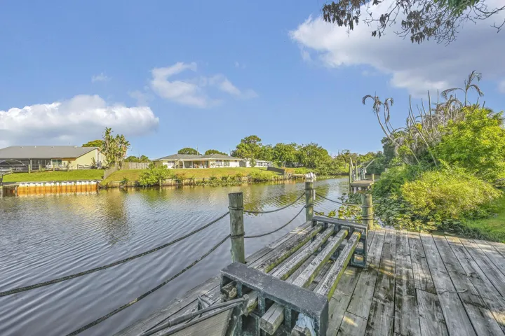 Waterfront dock featuring weathered wood planks and integrated seating, with boat tie-ups