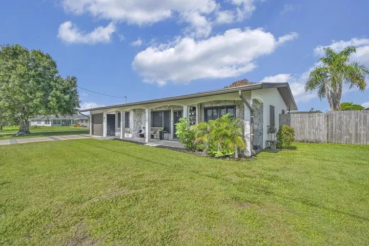 Exterior featuring a stone facade, covered porch, and a fenced backyard
