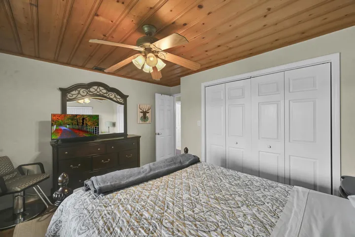 Wood-paneled ceiling featuring a ceiling fan with integrated lighting