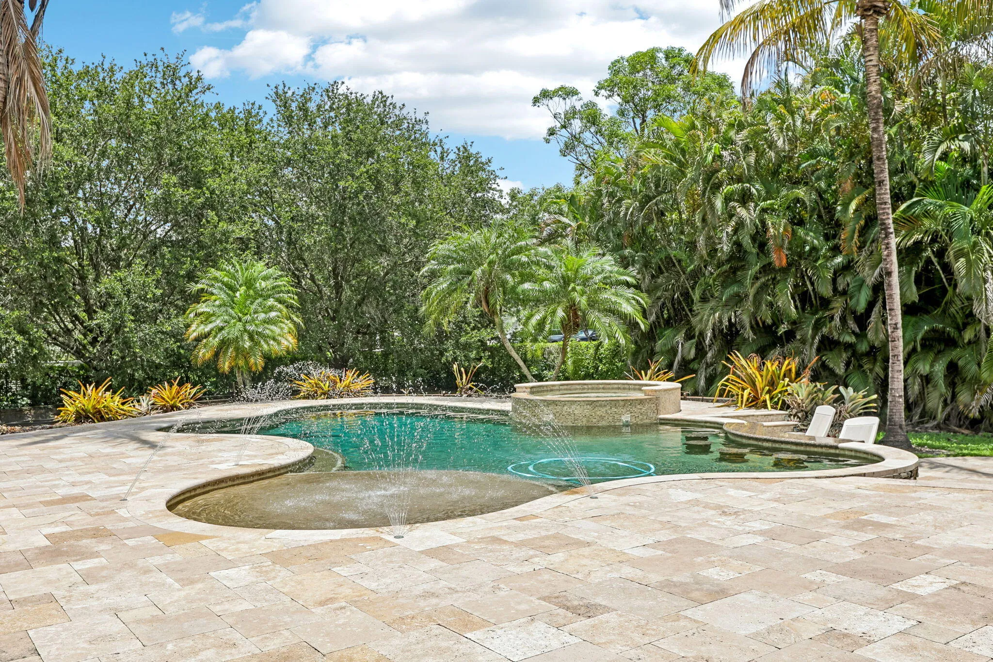 Curved swimming pool with integrated spa and sun shelf