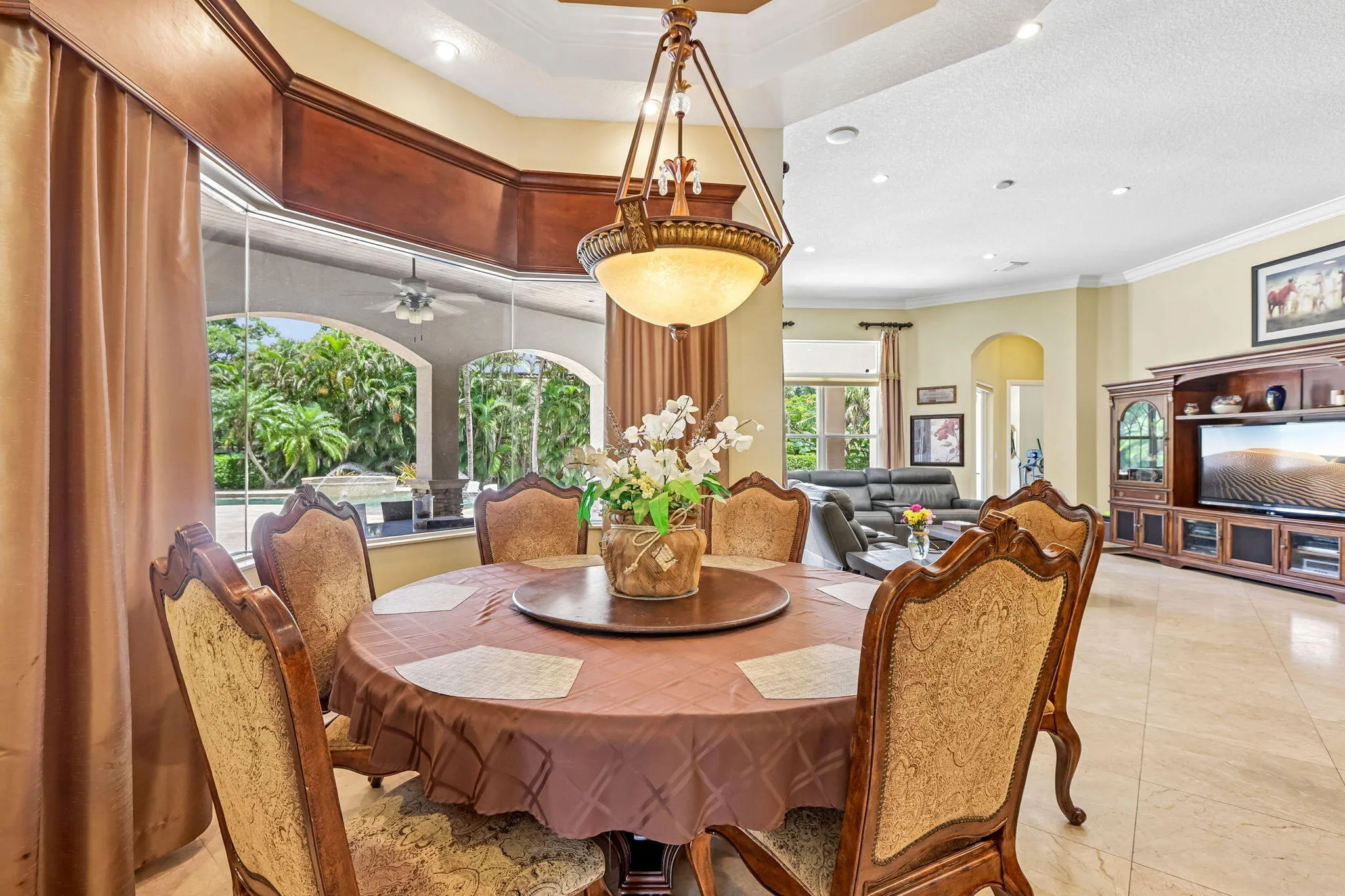 Dining area featuring a circular table, ornate chandelier, and large bay windows