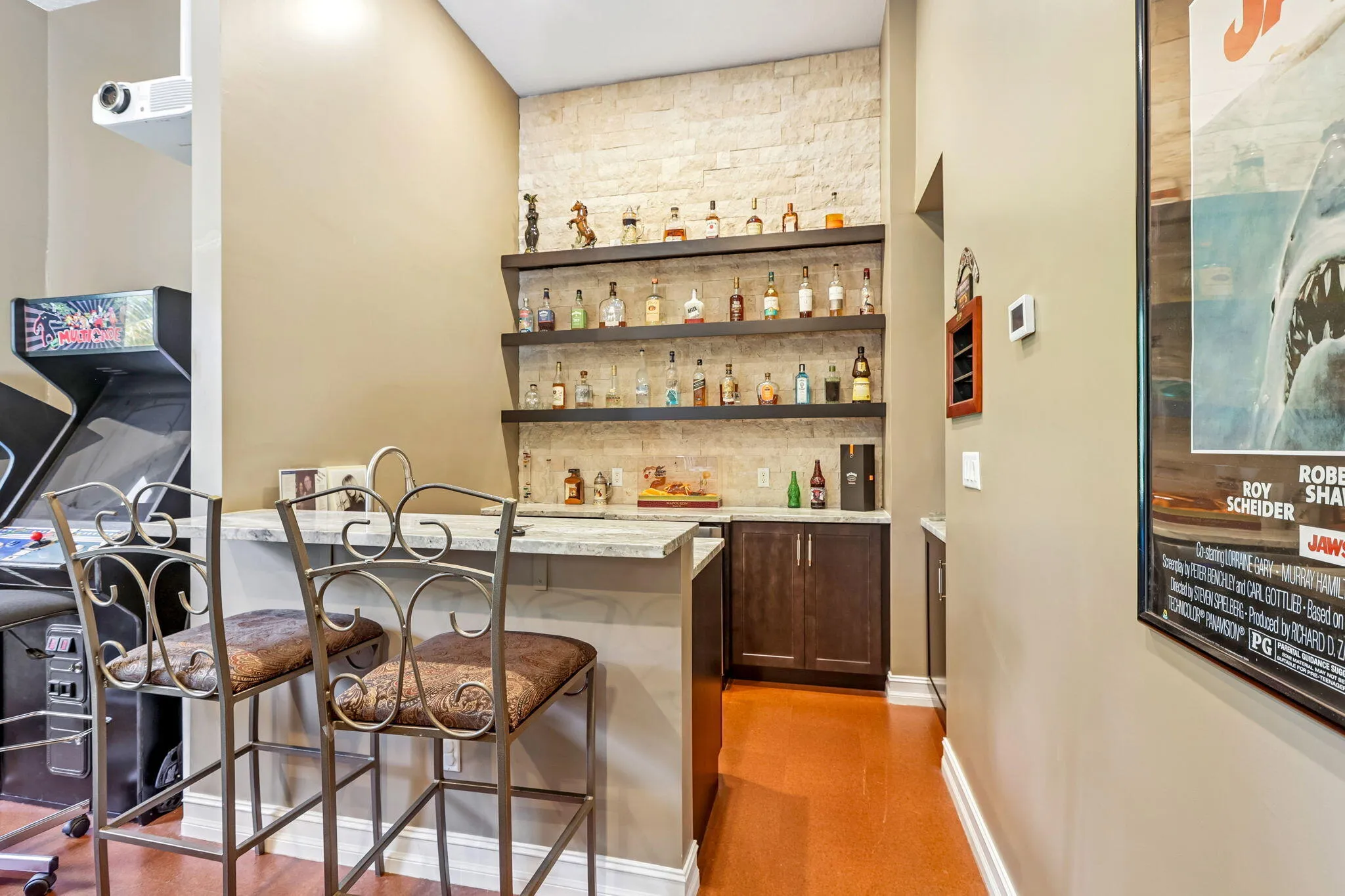 Built-in bar featuring a stone accent wall, floating wood shelves, and wood-finish flooring