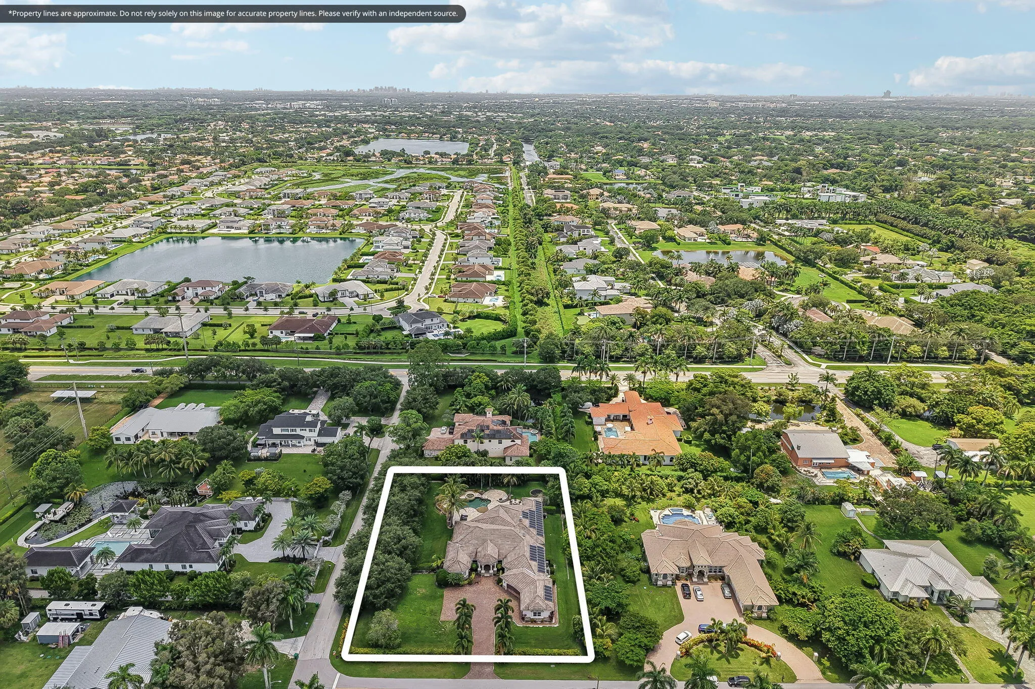 Expansive property featuring a large residence, circular driveway, mature landscaping, and a substantial backyard