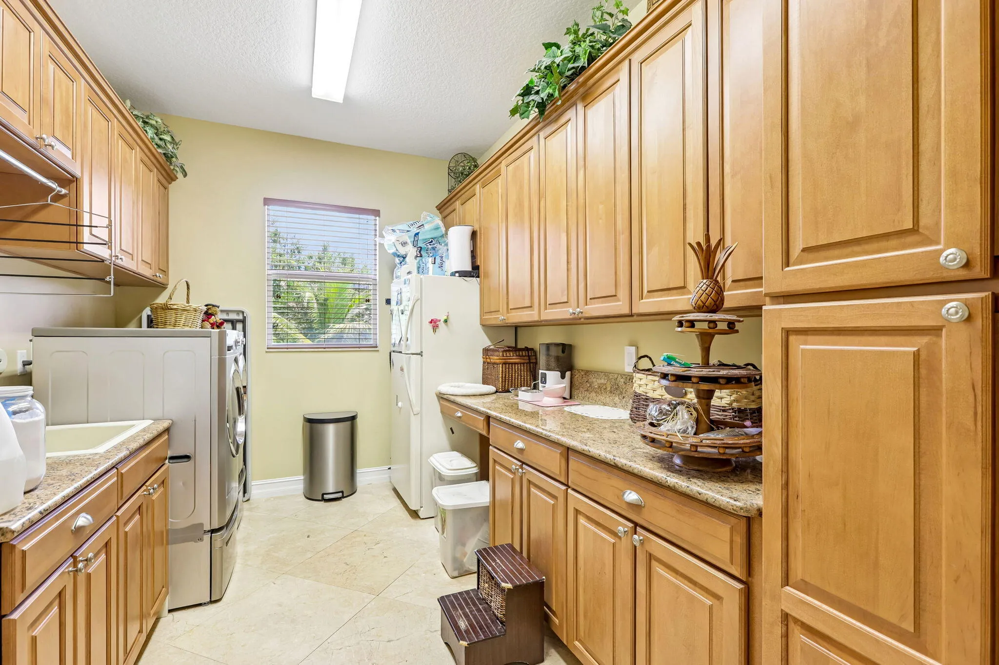Utility room featuring extensive wood-finish cabinetry, light-toned countertop, and recessed lighting