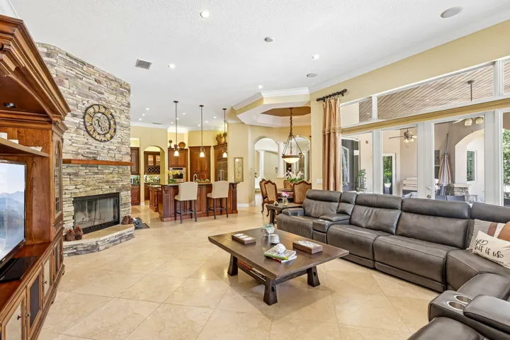 Expansive living area featuring large format tile flooring and a stacked stone fireplace with an integrated hearth