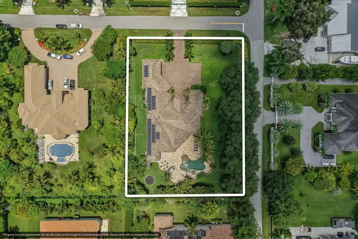 Expansive property featuring a large residence with a multi-gabled tile roof, an integrated swimming pool with a spa, and extensive solar panel installations