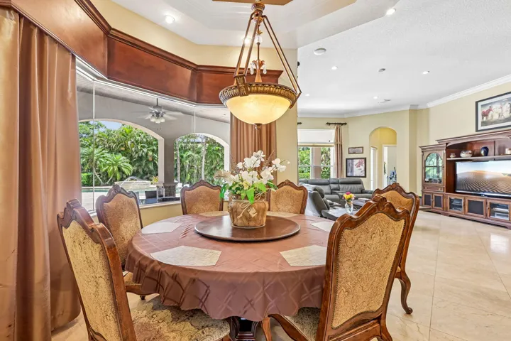 Dining area featuring a circular table, ornate chandelier, and large bay windows